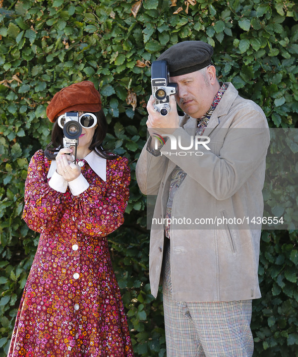 People in vintage clothes pose with vintage cameras at the Goodwood Revival 2016 in Goodwood, near Chichester in south England, on Sept. 11,...