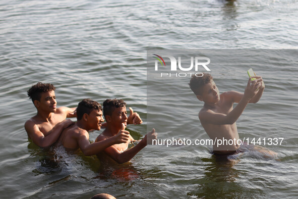 Egyptian boys take selfie in the River Nile at the Qanater Bridge during the Eid al-Adha festival in Qaliubiya, Egypt on Sept. 14, 2016.