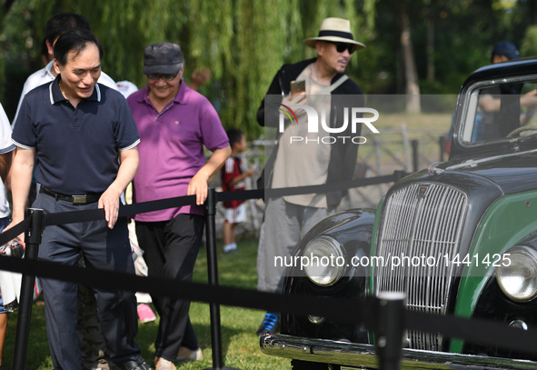 Visitors watch a vintage car during a vintage vehicle fair in Beijing, capital of China, Sept. 15, 2016. More than 100 vintage vehicles were...