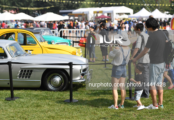 Visitors watch vintage cars during a vintage vehicle fair in Beijing, capital of China, Sept. 15, 2016. More than 100 vintage vehicles were...