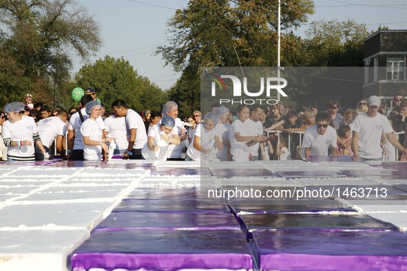 A giant cake is on display at a park in Bishkek, Kyrgyzstan, Sept. 25, 2016. A cake measuring 1.5 tons and 100 square meters was prepared by...