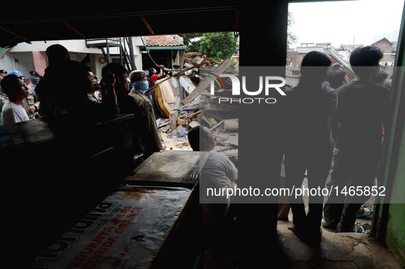 People watch an excavator demolishing their houses at Bukit Duri, a slum area in Jakarta, Indonesia, Sept. 28, 2016. The Jakarta city admini...