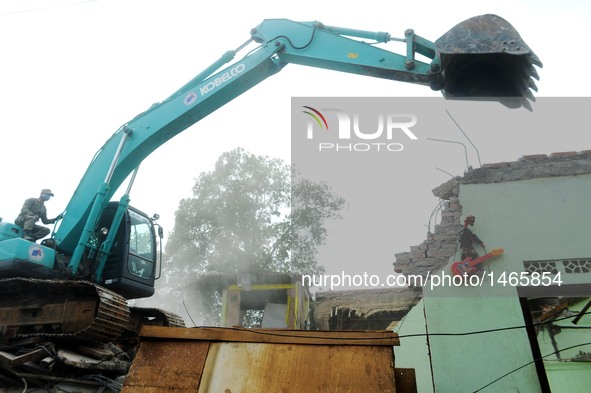 An excavator demolishes houses at Bukit Duri, a slum area in Jakarta, Indonesia, Sept. 28, 2016. The Jakarta city administration started to...