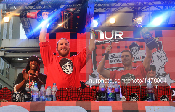 Joey Chestnut (L Front) of the United States celebrates victory during the 7th Annual World Poutine Eating Championship in Toronto, Canada,...