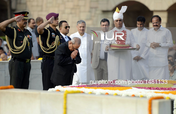 Indian President Pranab Mukherjee (Front) pays tribute to Mahatma Gandhi during a remembrance ceremony for his 147th birth anniversary at Ra...