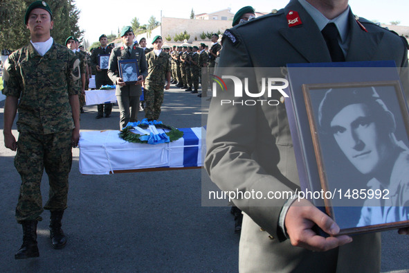 Soldiers carry the coffins and photographs during a handover remains ceremony at a military cemetery in Nicosia, Cyprus, on Oct. 4, 2016. Cy...