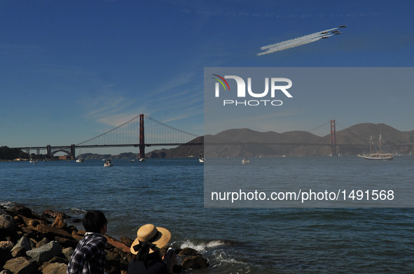 Two people watch the air show in San Francisco, the United States, on Oct. 8, 2016. An air show featuring the U.S. Navy Blue Angeles, the Ai...