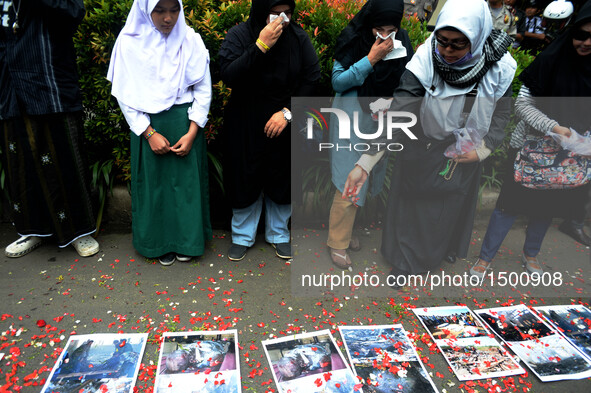 A woman scatters flowers during a rally protesting airstrikes at a funeral hall in Yemen, in front of Saudi Arabian embassy in Jakarta, Indo...