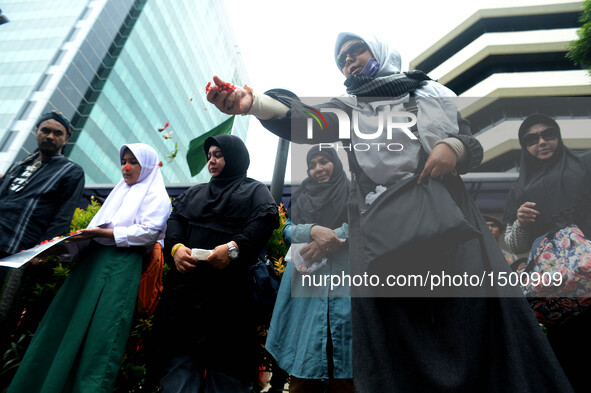 A woman scatters flowers during a rally protesting airstrikes at a funeral hall in Yemen, in front of Saudi Arabian embassy in Jakarta, Indo...