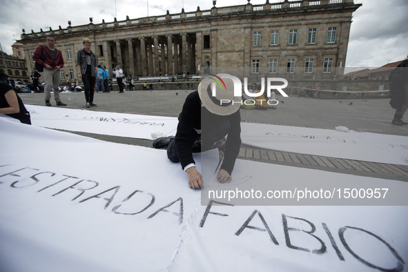 People sew white cloths with names of victims of the conflicts between the Revolutionary Armed Forces of Colombia (FARC) and the government,...