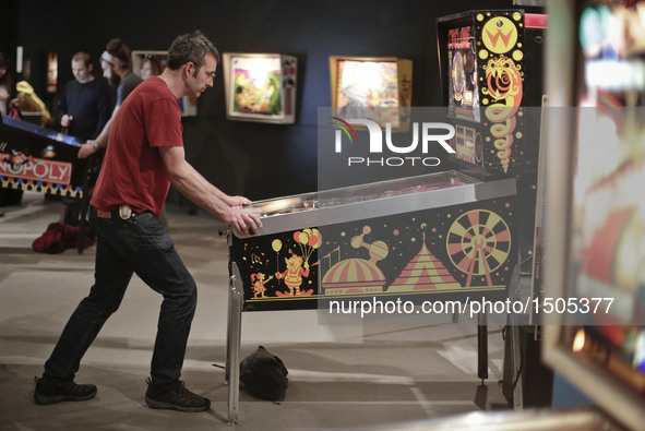 A contestant plays with a pinball machine during the Public Pinball Tournament in Vancouver, Canada, Oct. 13, 2016. People participated in t...