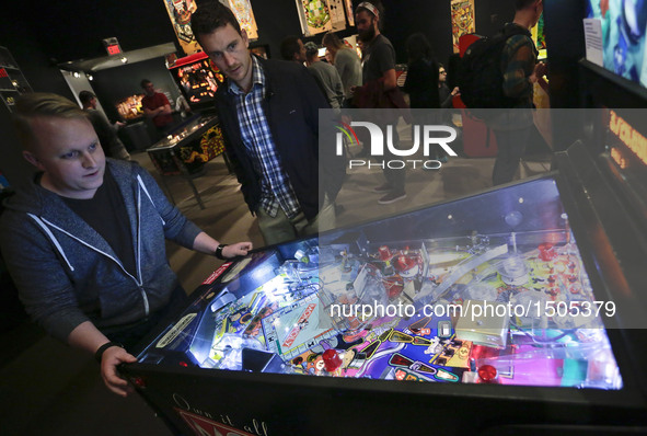 A contestant plays with a pinball machine during the Public Pinball Tournament in Vancouver, Canada, Oct. 13, 2016. People participated in t...