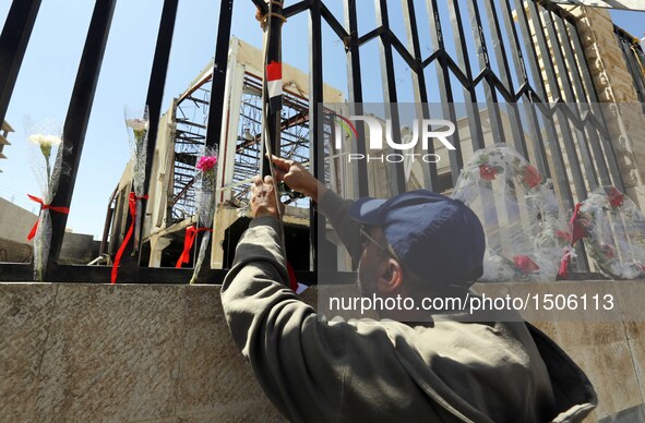 A Yemeni places roses during a rally in solidarity and honor of the Oct. 8 airstrikes' victims outside the funeral hall, in Sanaa, Yemen, Oc...