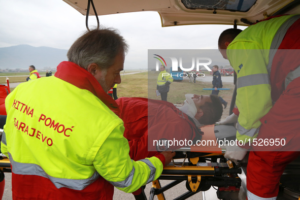 Medical workers put a "wounded person" into ambulance during an emergency rescue drill at Sarajevo International Airport, Bosnia and Herzego...