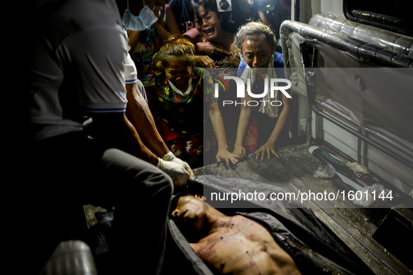 (EDITORS NOTE: Image depicts graphic content.) Relatives weep over the corpse of a suspected drug pusher after he was shot dead following a...