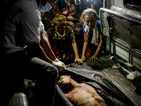 (EDITORS NOTE: Image depicts graphic content.) Relatives weep over the corpse of a suspected drug pusher after he was shot dead following a...