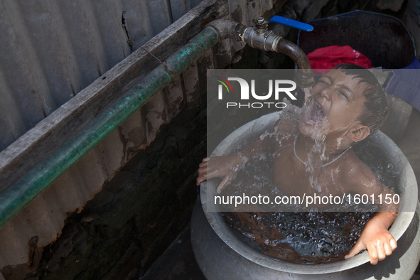 A child is taking shower in a slum. Narayanganj, near the capital city of Dhaka, Bangladesh. July 27, 2016 