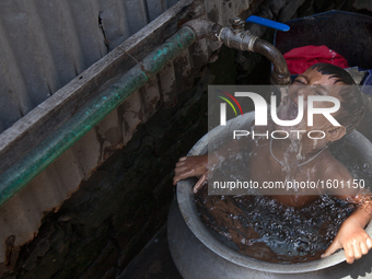 A child is taking shower in a slum. Narayanganj, near the capital city of Dhaka, Bangladesh. July 27, 2016 (