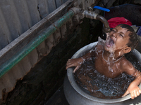 A child is taking shower in a slum. Narayanganj, near the capital city of Dhaka, Bangladesh. July 27, 2016 (