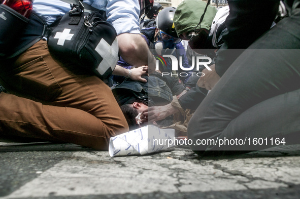 Team medic and photographer helping a demonstrator injured by a cop during a protest against proposed labour reforms in Paris on June14, 201...