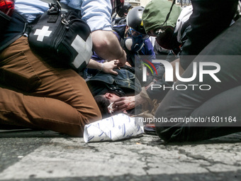 Team medic and photographer helping a demonstrator injured by a cop during a protest against proposed labour reforms in Paris on June14, 201...