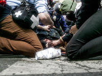 Team medic and photographer helping a demonstrator injured by a cop during a protest against proposed labour reforms in Paris on June14, 201...