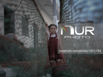 Palestinian fisherman's daughter accompany father when working as before going out to the sea, in Gaza, on November 14, 2016. (