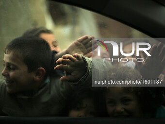 Palestinian children play in a poverty-stricken quarter on a rainy day of Beit Lahia town, in the northern Gaza Strip, on January 25, 2016....