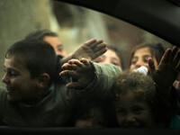 Palestinian children play in a poverty-stricken quarter on a rainy day of Beit Lahia town, in the northern Gaza Strip, on January 25, 2016....