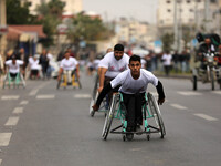 Palestinian men on their wheelchairs compete in a marathon organised for Palestinians who have been wounded by wars, on November 29, 2016 in...