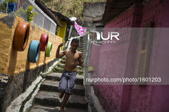 A boy is seen playing with a kite. Project to leave the visually pleasing favelas is put into practice in the community of Corrego do Jenipa...