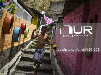 A boy is seen playing with a kite. Project to leave the visually pleasing favelas is put into practice in the community of Corrego do Jenipa...