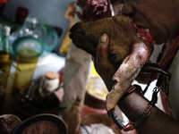 A man takes fresh blood on the head of a ram that has been offered to spiritual deities. Members of the Jurema religion make animal sacrific...