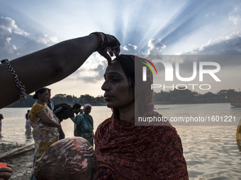 A woman putting tilak on her forehead after taking a holy dip into the river during the Chhath Puja festival in Kolkata, West Bengal on Devo...