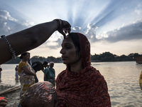 A woman putting tilak on her forehead after taking a holy dip into the river during the Chhath Puja festival in Kolkata, West Bengal on Devo...