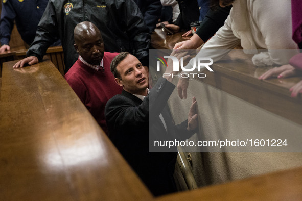 South African Paralympian athlete Oscar Pistorius holds the hand of a relative as he leaves Pretoria High Court, South Africa, on July 6, 20...