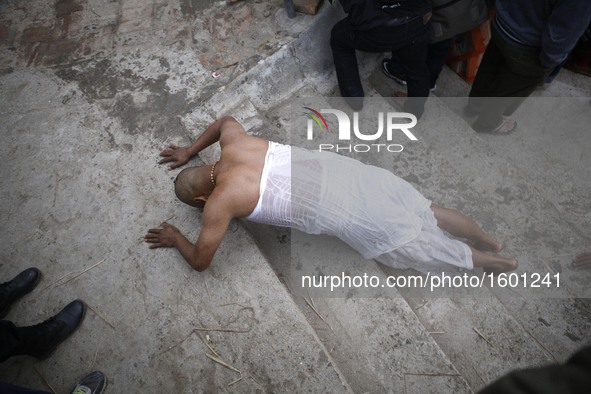 A Nepalese Hindu devotee rolls on the ground as a part of ritual after taking holy bath in the Shali River on the first day of Madhav Naraya...