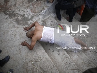 A Nepalese Hindu devotee rolls on the ground as a part of ritual after taking holy bath in the Shali River on the first day of Madhav Naraya...