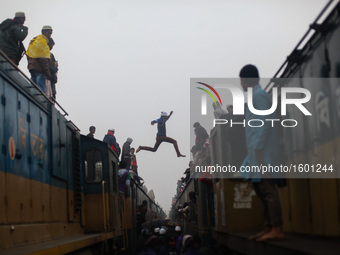 A boy jumps from one train to another train to ensure his seat as there are lots of people arrives today to attend final prayer of "Bishwa I...