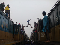 A boy jumps from one train to another train to ensure his seat as there are lots of people arrives today to attend final prayer of "Bishwa I...