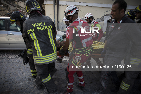 Rescuers carry a man from the rubble after a strong earthquake hit Amatrice on August 24, 2016. Central Italy was struck by a powerful, 6.2-...