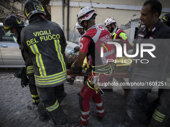 Rescuers carry a man from the rubble after a strong earthquake hit Amatrice on August 24, 2016. Central Italy was struck by a powerful, 6.2-...