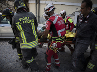 Rescuers carry a man from the rubble after a strong earthquake hit Amatrice on August 24, 2016. Central Italy was struck by a powerful, 6.2-...