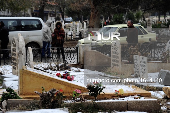 A Syrian man walks by the graves in a garden in the Hamidiyeh neighborhood of Aleppo city, Syria, on Dec. 21, 2016. Due to the intensity of...