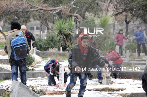 Syrian children play in a graveyard which used to be a garden in the Hamidiyeh neighborhood of Aleppo city, Syria, on Dec. 21, 2016. Due to...