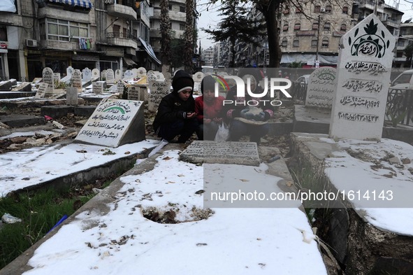 Syrian children pray in front of a grave in a garden in the Hamidiyeh neighborhood of Aleppo city, Syria, on Dec. 21, 2016. Due to the inten...