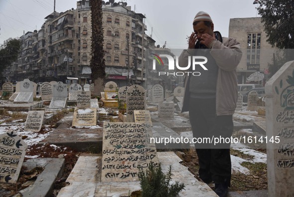 Muhammad Fahid prays in front of the grave of his late wife in a garden in the Hamidiyeh neighborhood of Aleppo city, Syria, on Dec. 21, 201...