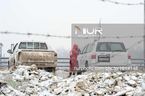 Red Crescent vehicles wait for the evacuation of rebels in Ramouseh area, south of Aleppo city, northern Syria, on Dec. 21, 2016. A Syrian m...