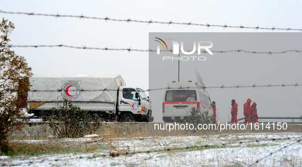 Red Crescent vehicles wait for the evacuation of rebels in Ramouseh area, south of Aleppo, northern Syria, on Dec. 21, 2016. A Syrian milita...