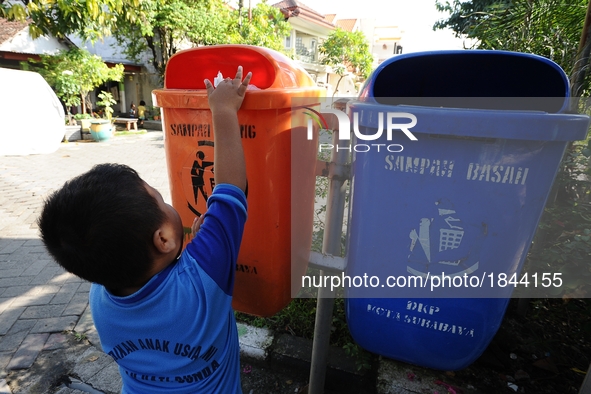 A boy throws the garbage into trash can.
Surabaya Municipality Government has developed an effective community education program about waste...